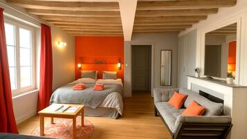 Une chambre d’hôtel avec un lit, un canapé, une table et une cheminée.