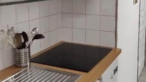 Eine Küche mit Mikrowelle, Spüle und Edelstahlbesteck.