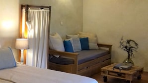 Ein gemütliches Schlafzimmer mit einem Bett, einer hölzernen Bank und einem Nachttisch.