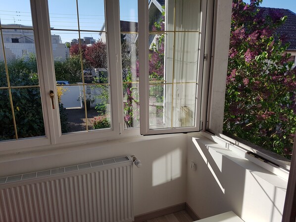 A corner room with a view of a garden and neighboring buildings. - lilac Maladière (Dijon)