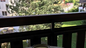 Een tafel met kandelaar op een balkon met uitzicht op een woonwijk.