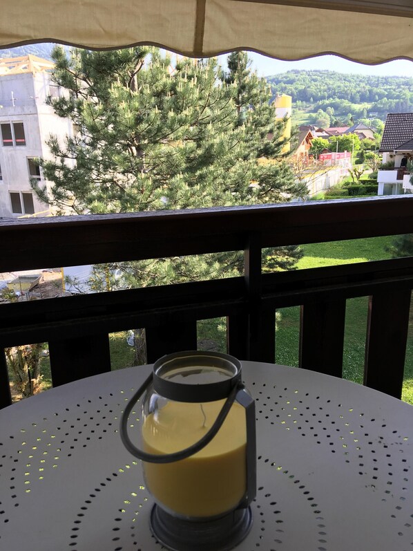A table with a candle holder on a balcony overlooking a residential area.