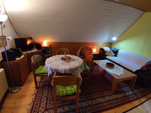 Cozy living space with a high ceiling, dining area, and comfortable seating area.