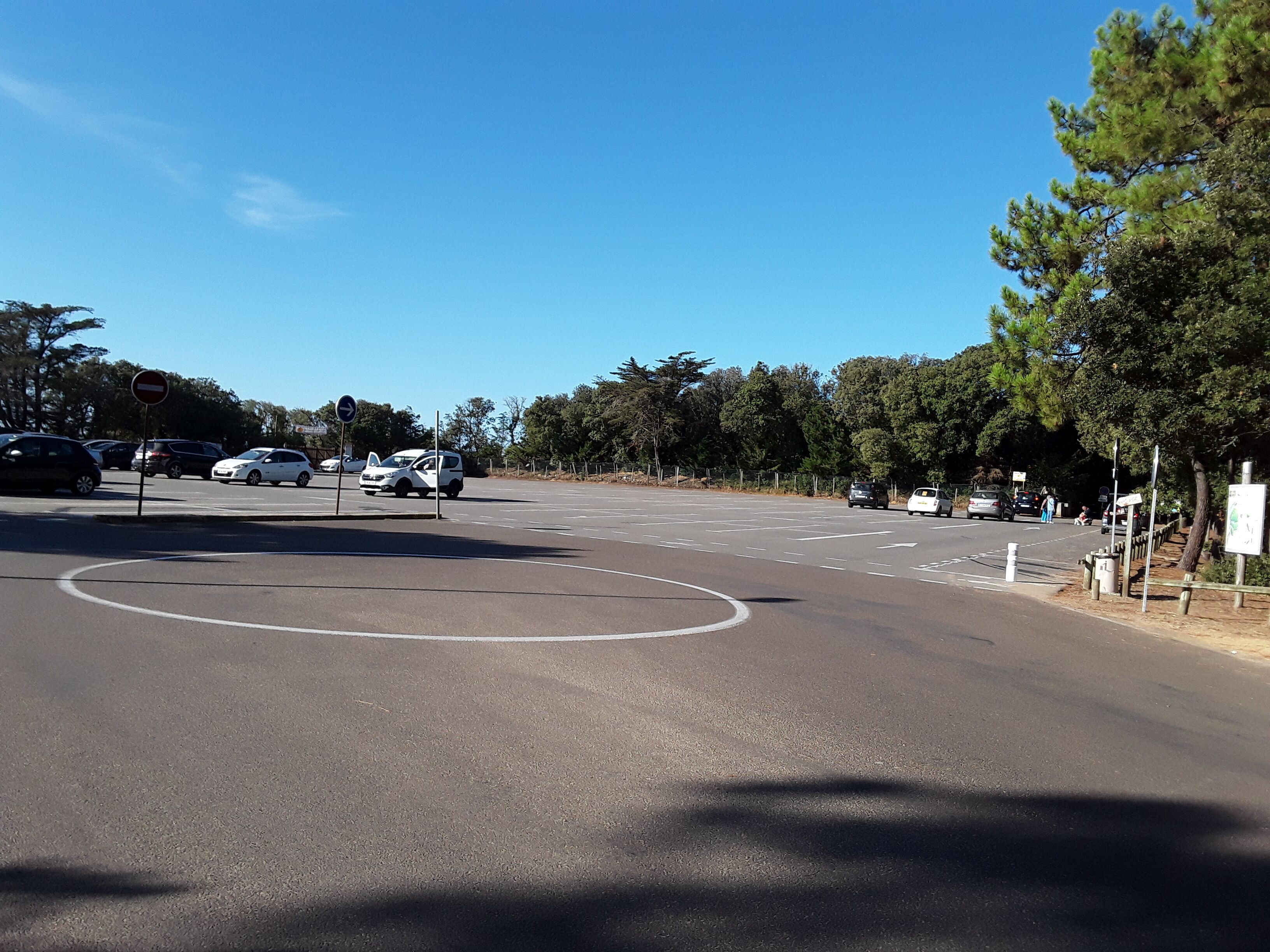 Un estacionamiento con carriles señalizados y un letrero de 'prohibido el acceso'.