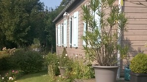 A house with a garden, a lawn, and a wooden deck. - Charming cottage 200 meters from the beach, in beautiful wooded property (Veulettes-sur-Mer)