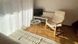 Makuuhuoneessa on sänky, televisio, tuoli ja pieni pöytä.