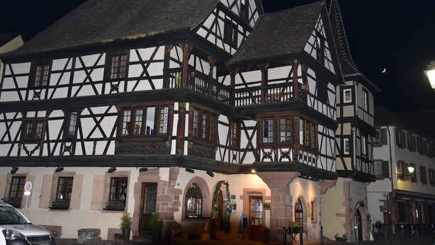 A traditional half-timbered building with multiple windows and a balcony.