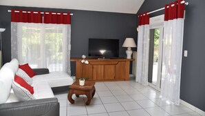 A living room with a sofa, a coffee table, a TV, and a cabinet.
