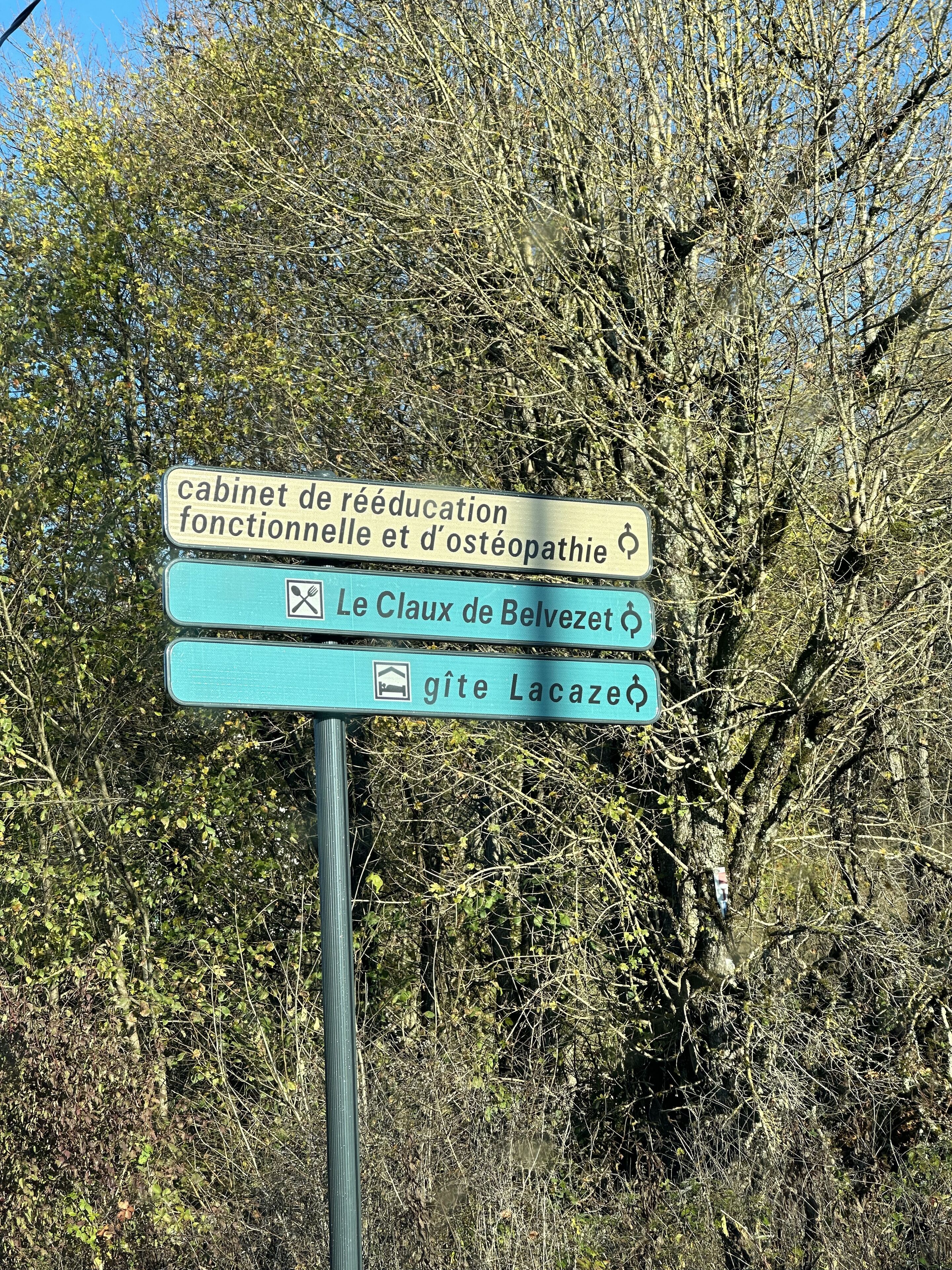 Een richtingsbord met verschillende bestemmingen, waaronder een revalidatiecentrum, een kliniek en Lacaze.