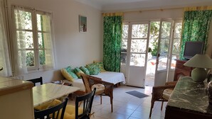 A room with a bed, a dining table, chairs, a TV, and a window with curtains. - T2 ground floor Carry le Rouet (Carry-Le-Rouet)