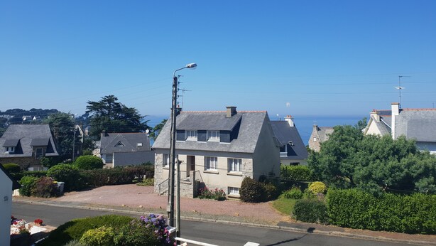 A residential area with houses, a street lamp, and a clear blue sky. - Guirec Dogs (Perros-Guirec)