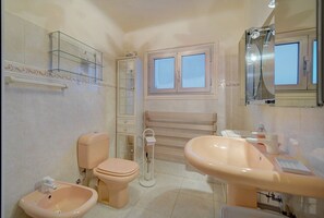 Bathtub, hair dryer, towels, toilet paper
