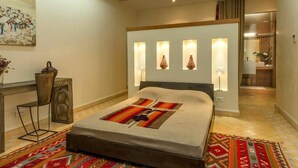 A bedroom with a bed, bedside table, chair, and a wall-mounted light fixture. - Villa Kristy Junior (2 bedrooms + Private pool) (Marrakesh)