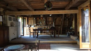 A rustic wooden interior with a dining area, kitchen, and a staircase leading to an upper level. - 100 years old  BARN revovated (Castets)
