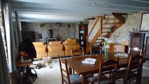 A dining area with a wooden table and chairs, a staircase, and a dog lying on the floor.