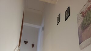 A staircase with a handrail, white walls, and a framed picture on the wall.
