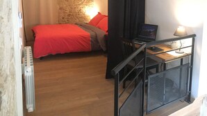 A bedroom with a bed, a desk with a computer, a lamp, and a ceiling fan. - Arena & Maison Carrée (free parking, fully air-conditioned accommodations) (Nîmes)