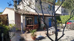 A Mediterranean-style villa with a tiled patio, outdoor seating, and potted plants. - Air-conditioned Provencal villa, 300 m2 garden, quiet location, walking distance to beaches and village (Villeneuve-Loubet)