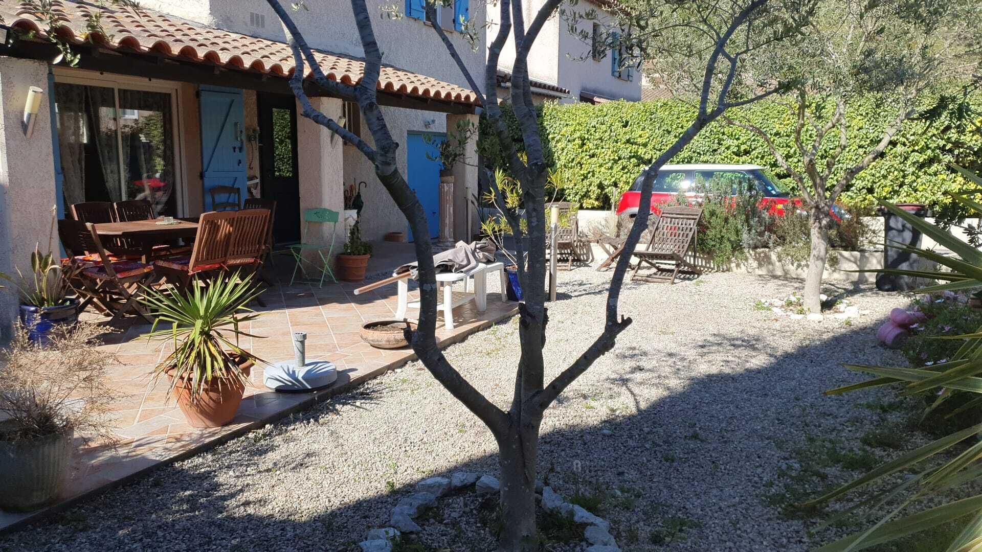 A courtyard with a patio, outdoor furniture, and a car parked nearby.