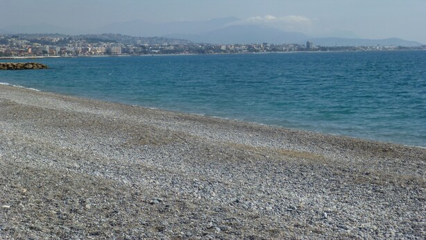 A pebble beach with a cityscape in the background. - Air-conditioned Provencal villa, 300 m2 garden, quiet location, walking distance to beaches and village (Villeneuve-Loubet)