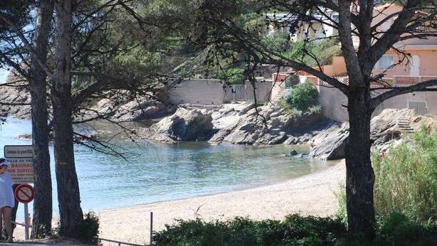 Une route côtière bordée d’une plage et de formations rocheuses.