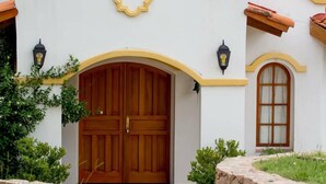 Un bâtiment de style méditerranéen, doté d’une grande porte en bois, de fenêtres en arc de cercle et d’une antenne parabolique.