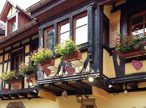 A traditional building with multiple windows, some with flower boxes and heart-shaped decorations. - Oriel - Village centre, terrace and private car park (Eguisheim)