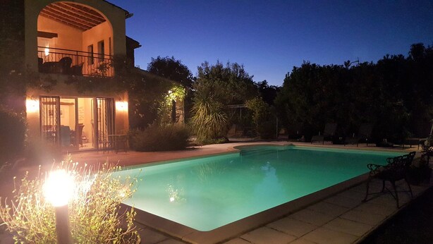 A swimming pool with a house in the background.