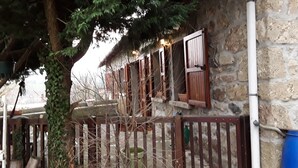 A stone building with wooden shutters, a metal gate, and a tree in front. - GRANGE-GITE by ROCHEBARON (bas en basset)