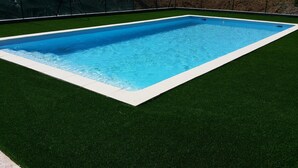 A rectangular swimming pool with a white edge, surrounded by artificial green grass. - Pool, family rooms, breakfast (Seysses-Savès)