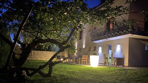 Uma casa com varanda, área de estar externa e um gramado bem cuidado.
