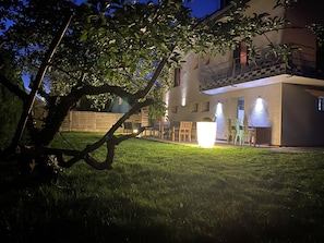 Une maison dotée d’un balcon, d’un espace extérieur aménagé pour s’asseoir et d’une pelouse bien entretenue.
