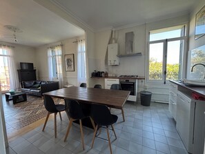 Una cucina moderna con zona pranzo, ampie finestre e camino.