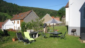 A backyard with a dining table, chairs, and a barbecue grill. -  in the village of Lapoutroie 10 km from Kaysersberg (Lapoutroie)