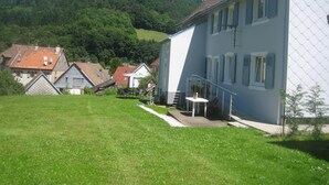 A residential area with houses, a grassy lawn, and a hill in the background. -  in the village of Lapoutroie 10 km from Kaysersberg (Lapoutroie)