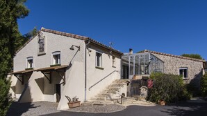 A two-story stone building with a staircase leading to the upper floor. - VILLA WITH COVERED SWIMMING POOL HEATED TO 28°, FULLY AIR CONDITIONED IN SERIGNAN (Sérignan)