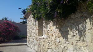 Mur de pedra amb una finestra petita i un fanal.