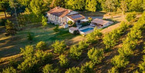 An aerial view of a large house with a swimming pool, surrounded by trees and a well-maintained lawn. - Gîte de groupe, 37 places, 13 rooms (La Romieu)