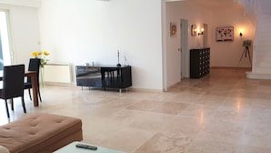 A spacious living area with a dining table, chairs, a sofa, and a cabinet. - House 2 minutes walk from the sea (La Ciotat)