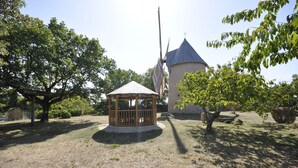 A gazebo in a park with a windmill in the background.