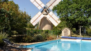 A windmill, a swimming pool, and lounge chairs.