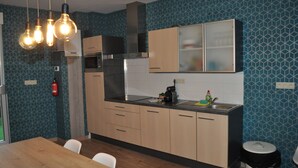 Eine moderne Küche mit Holzschränken, einem Edelstahlspülbecken und einem eingebauten Backofen.