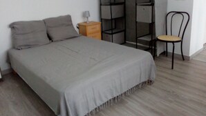 Une chambre à coucher comprenant un lit, une table de chevet, une chaise et une armoire.