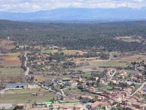 A rural village with houses, fields, and a road.
