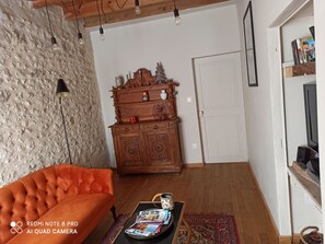 Uma sala de estar acolhedora com um armário de madeira, um sofá vermelho e uma mesa de centro com revistas.