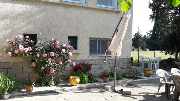 A patio area with potted plants, a yellow pot, and outdoor furniture. - seasonal rental of a villa in the countryside (Meynes)