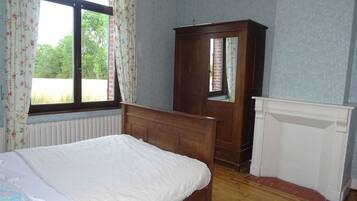 Une chambre à coucher avec un lit en bois, une armoire et un radiateur.