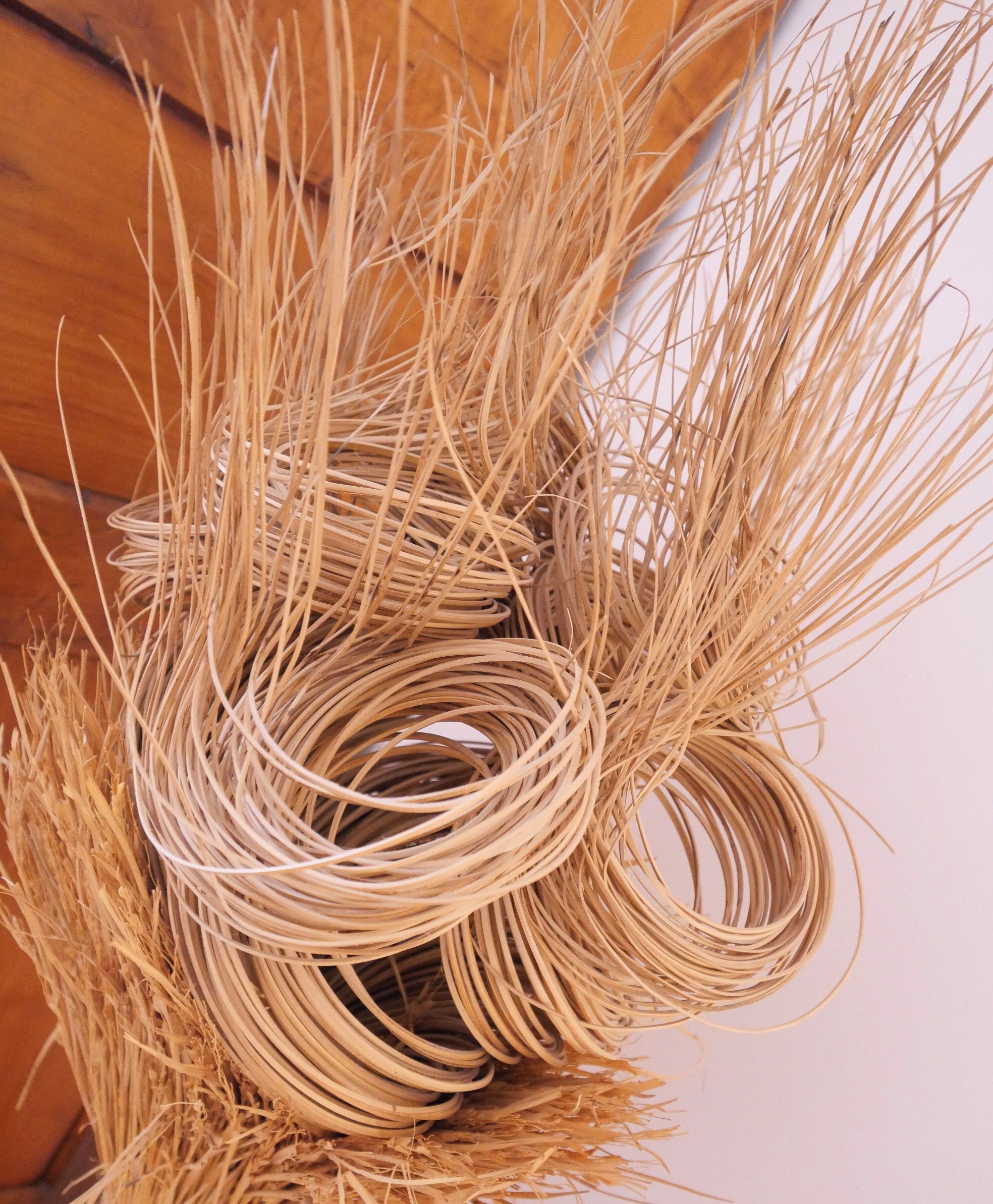 A close-up of a woven basket made of straw, with a wooden background.
