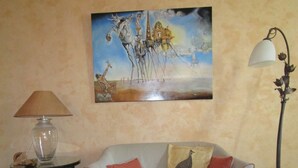 A living room with a sofa, a lamp, a table, and a painting on the wall. - Haven of peace in the center of Versailles (Versailles)