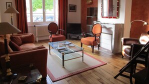 A living room with a sofa, two armchairs, a coffee table, a TV, and a fireplace. - Haven of peace in the center of Versailles (Versailles)